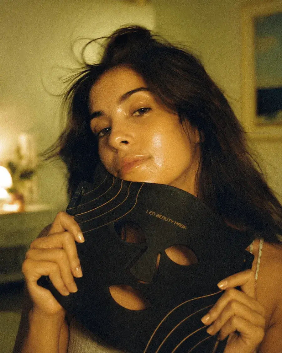 A woman holding the Aureum LED mask, shot on film